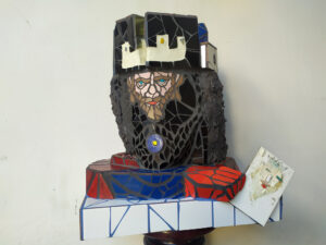 Ritratto del Re con autoritratto da giovane. Mosaico ceramico e stucchi su poliuretano espanso. Cm 62x42x72. 2023